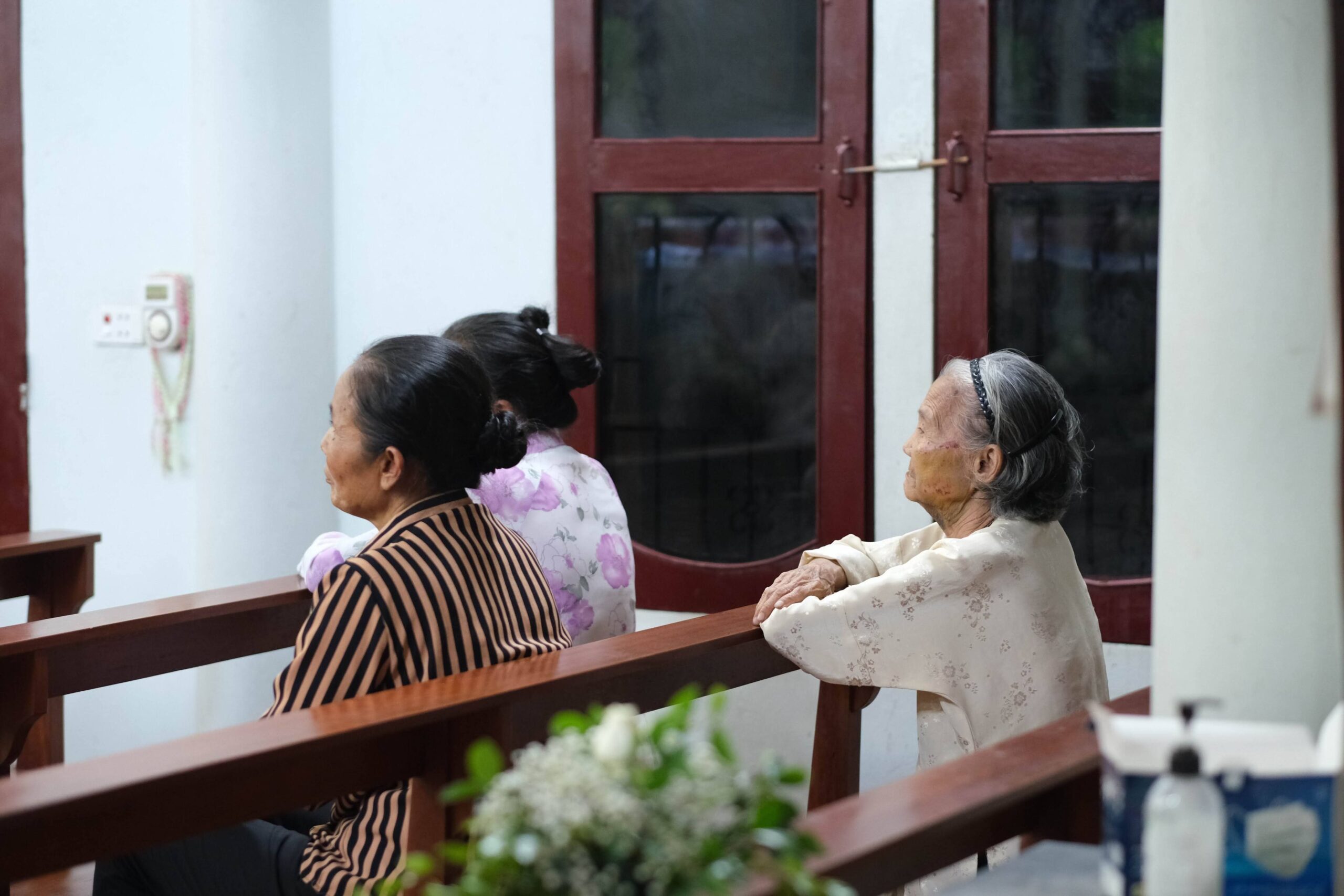 Three senior women seated indoors, engaged in thoughtful contemplation.